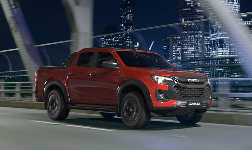Isuzu Ute driving on a bridge with a city skyline in the background